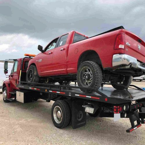 Camioneta roja entregada sobre plataforma de grúa