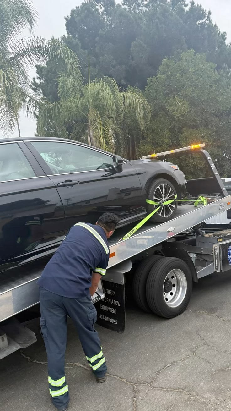 Operador Serviruta asegurando un auto sobre la plataforma de la grúa